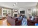 Inviting living room featuring plush sofas, a cozy fireplace, and natural light from large windows at 1028 Bellenden Dr, Durham, NC 27713