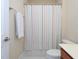 This bathroom features a striped shower curtain, white towels, a toilet, and modern fixtures at 10529 Sablewood Dr # 116, Raleigh, NC 27617