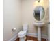 Charming powder room with pedestal sink, oval mirror, and hardwood flooring at 10529 Sablewood Dr # 116, Raleigh, NC 27617