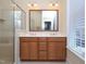 Bathroom with double vanity, large mirror, enclosed shower, and natural light at 10529 Sablewood Dr # 116, Raleigh, NC 27617