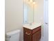 This bathroom includes a wooden vanity with a white sink, a toilet, and a decorative mirror at 10529 Sablewood Dr # 116, Raleigh, NC 27617