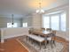 Open-concept dining room with a wooden table, chandelier, and an adjacent living area at 10529 Sablewood Dr # 116, Raleigh, NC 27617