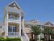 Charming townhome exterior showcasing a double balcony, white trim, and a neatly landscaped yard at 10529 Sablewood Dr # 116, Raleigh, NC 27617