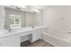 Bright bathroom featuring a double sink vanity and built in bathtub at 107 Caraleigh Ct, Morrisville, NC 27560