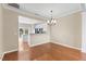 Dining area with hardwood floors, modern chandelier, and an open view into the adjacent kitchen at 107 Caraleigh Ct, Morrisville, NC 27560
