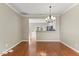 Dining area with hardwood floors, modern chandelier, and an open view into the adjacent kitchen at 107 Caraleigh Ct, Morrisville, NC 27560