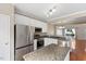 Spacious kitchen featuring white cabinets, granite countertops, stainless appliances, and dining area access at 107 Caraleigh Ct, Morrisville, NC 27560