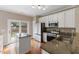 Modern kitchen with stainless steel appliances, granite countertops, and backyard access at 107 Caraleigh Ct, Morrisville, NC 27560