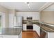 Well-equipped kitchen featuring white cabinets, granite countertops, and stainless steel appliances at 107 Caraleigh Ct, Morrisville, NC 27560