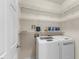 Functional laundry room with modern washer and dryer and shelving for storage at 107 Caraleigh Ct, Morrisville, NC 27560