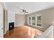 Bright living room with fireplace, ceiling fan, and large windows overlooking backyard at 107 Caraleigh Ct, Morrisville, NC 27560