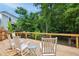 Relaxing back deck with wood chairs and table, perfect for enjoying the backyard and green scenery at 1102 Whiston Dr, Apex, NC 27502