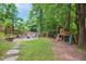 Backyard features a stone patio with seating, fire pit, custom built treehouse and swing set, great for entertaining at 1102 Whiston Dr, Apex, NC 27502