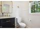 Stylish half bathroom with shiplap walls, a black vanity, brass fixtures, and a decorative starfish at 1102 Whiston Dr, Apex, NC 27502