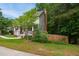 Suburban home featuring a lush front yard, mature trees, a charming covered front porch, and sidewalk at 1102 Whiston Dr, Apex, NC 27502