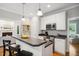 Open kitchen with white cabinets, black countertops, modern appliances, and a breakfast bar at 1102 Whiston Dr, Apex, NC 27502