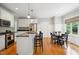 Kitchen with stainless appliances and island opens to the dining area with wood floors at 1102 Whiston Dr, Apex, NC 27502