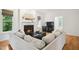 Bright living room featuring a fireplace, hardwood floors, comfortable seating and two large windows at 1102 Whiston Dr, Apex, NC 27502