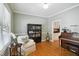 Inviting living room featuring hardwood floors, soft green walls and a white armchair at 1102 Whiston Dr, Apex, NC 27502