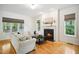 Bright and airy living room with hardwood floors, a fireplace, comfortable seating, and large windows at 1102 Whiston Dr, Apex, NC 27502