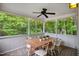 Inviting screened porch features wood table, seating for six, ceiling fan, and beautiful views of the wooded backyard at 1102 Whiston Dr, Apex, NC 27502