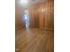 Bedroom featuring hardwood floors and wood paneled walls with view into bathroom area at 1157 S Cambridge Cir, Rocky Mount, NC 27801