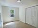 A bright bedroom with laminate flooring, white closet doors and window at 116 Lumpkin St, Raleigh, NC 27610