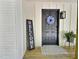 Charming front door with a floral wreath, wooden welcome sign, and quaint farmhouse lighting at 116 Lumpkin St, Raleigh, NC 27610