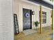 Charming front porch featuring a black door, welcome sign, wood columns, and farmhouse lantern at 116 Lumpkin St, Raleigh, NC 27610
