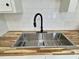 Close-up of a stainless steel kitchen sink with a modern faucet and butcher block countertop at 116 Lumpkin St, Raleigh, NC 27610