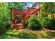 Backyard deck with a pergola and grill amidst lush greenery and mature trees at 12 Byerly Ct, Durham, NC 27713