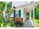 Inviting entrance with a covered porch, green front door, brick accents, and an outdoor light fixture at 12 Byerly Ct, Durham, NC 27713