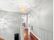 Upstairs hallway with hardwood floors, modern lighting, and access to bedrooms and bathrooms at 12 Byerly Ct, Durham, NC 27713