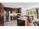 Modern kitchen with stainless steel appliances, dark wood cabinets, granite countertops, and an eat-in area at 12 Byerly Ct, Durham, NC 27713