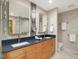 Well-lit bathroom featuring dual sinks, wood cabinets, modern fixtures, and a large mirror at 120 Spring Hollow Ln, Cary, NC 27518