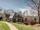Community clubhouse with a manicured lawn, featuring an outdoor deck, and surrounded by trees under a blue sky at 120 Spring Hollow Ln, Cary, NC 27518