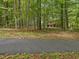 Exterior view of home through the trees showcasing natural surroundings and a tranquil setting at 120 Spring Hollow Ln, Cary, NC 27518