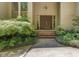 Inviting front entrance with brick steps leading to double wooden doors and surrounded by lush landscaping at 120 Spring Hollow Ln, Cary, NC 27518