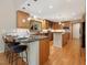 Modern kitchen with granite countertops, breakfast bar, wood cabinets, stainless steel appliances, and hardwood floors at 120 Spring Hollow Ln, Cary, NC 27518