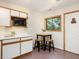 Cozy kitchenette with white cabinets, wood trim, and a small dining table with seating at 120 Spring Hollow Ln, Cary, NC 27518