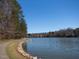 Scenic lake view with walking path and lush trees, offering a serene and picturesque setting at 120 Spring Hollow Ln, Cary, NC 27518