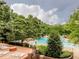 Outdoor pool area featuring lounge chairs, mature trees, and clear blue water at 120 Spring Hollow Ln, Cary, NC 27518