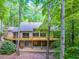 Lovely home exterior boasting a spacious wooden deck, large windows, and a walkout basement, all surrounded by lush trees at 120 Spring Hollow Ln, Cary, NC 27518