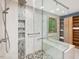 Bathroom featuring glass-door shower, neutral tile, and built-in shelving at 120 Spring Hollow Ln, Cary, NC 27518