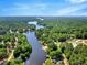 Expansive aerial view of a winding river surrounded by lush forests, showcasing waterfront homes and docks at 135 Sagamore Dr, Louisburg, NC 27549