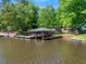 Scenic waterfront property featuring a covered boat dock, perfect for enjoying lake activities at 135 Sagamore Dr, Louisburg, NC 27549