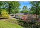 Inviting home exterior featuring vibrant flower beds, lush green lawn, and a quaint cottage-style design at 135 Sagamore Dr, Louisburg, NC 27549