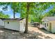 Picturesque home exterior featuring a boathouse, additional shed, and lush landscaping leading to the waterfront at 135 Sagamore Dr, Louisburg, NC 27549