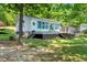 Charming home exterior featuring an inviting deck and lush green lawn with mature trees at 135 Sagamore Dr, Louisburg, NC 27549