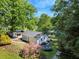 Inviting lake house showcasing lush landscaping, including vibrant azaleas, and a trampoline for outdoor fun at 135 Sagamore Dr, Louisburg, NC 27549